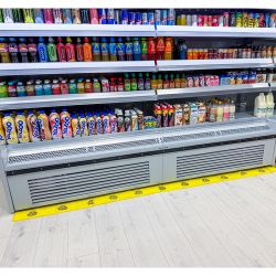 Bande absorbante eau PIG® Essentials installée devant un meuble frigorifique de supermarché