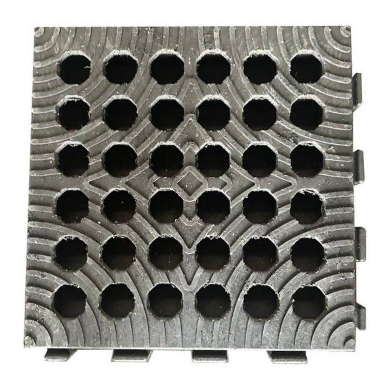 Vue de dessus d'une dalle de roulage ajourée avec perforations circulaires et ergots d'assemblage